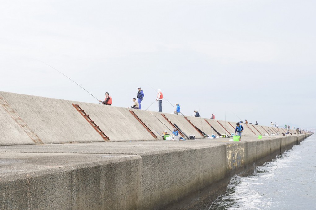 写真、武庫川一文字で釣りをする人々