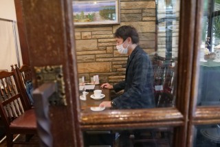 写真、喫茶店で取材を受ける成海さん