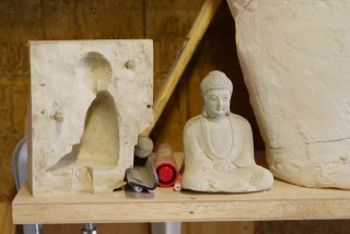 写真、前田さんの制作拠点に置いている、コンクリート製のミニ大仏とその型