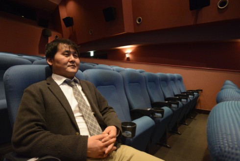 写真、劇場の座席に座る戸村さん