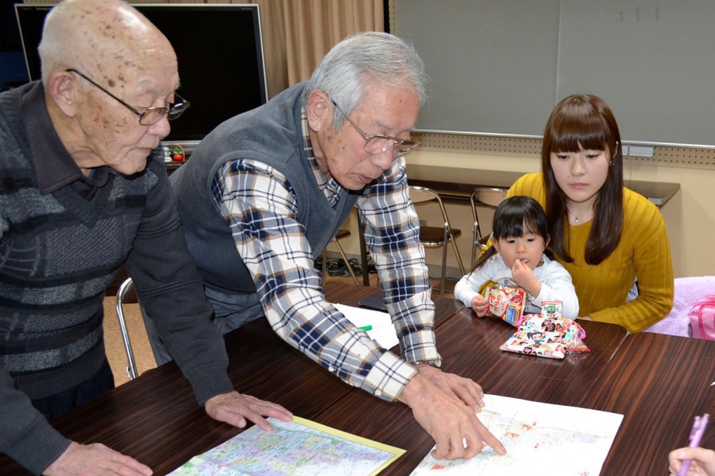 写真、地図を指で指しながら説明する古田会長