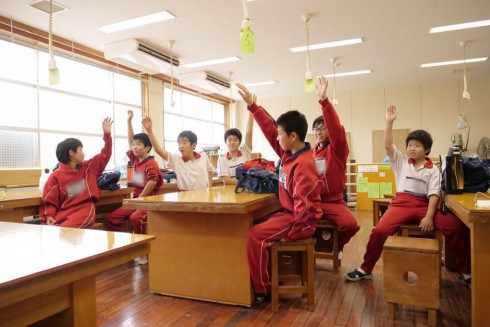 教室で手を挙げる生徒