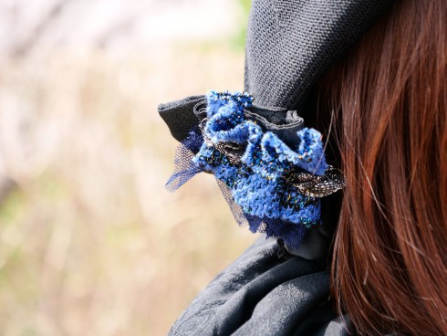 帽子に付いた青い花のコサージュ