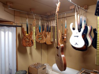 写真、工房内の様子。塗装後のエレキギターが並ぶ