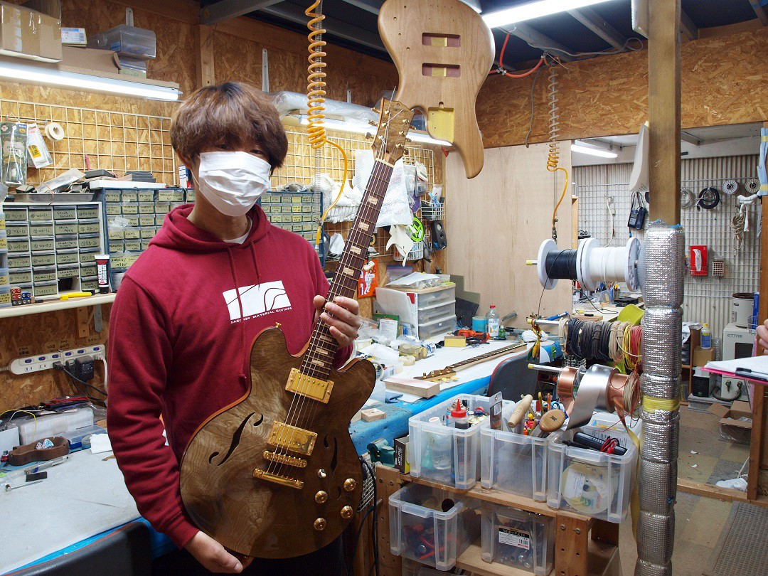 写真、メイドインジャパンのエレキギターを持つ高山さん