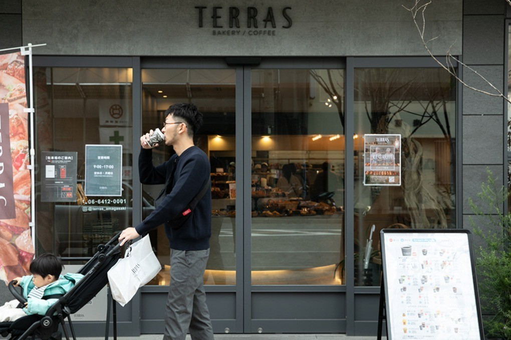 パン屋の店先でコーヒーを飲む多田さん