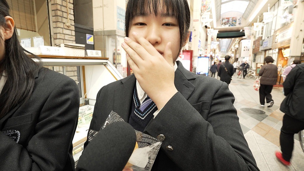 商店街で食レポする高校生