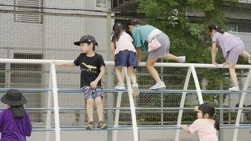 校庭の遊具で遊ぶこどもたち