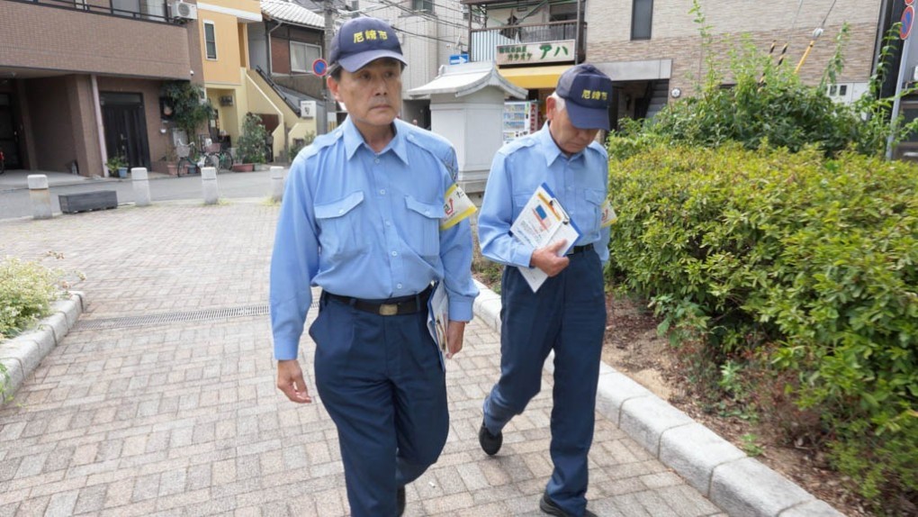 駅前を歩く指導員