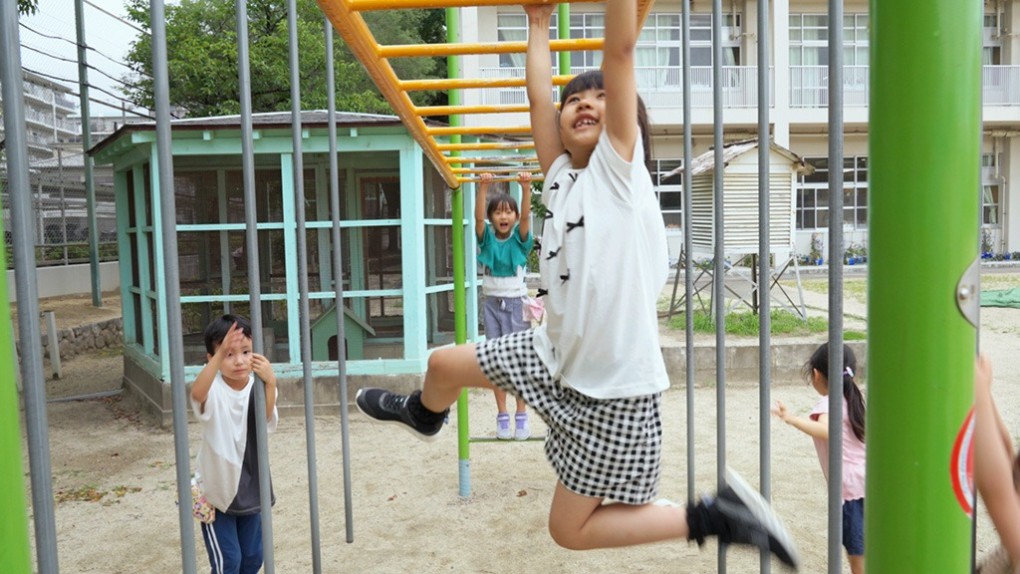 校庭の遊具で遊ぶ子どもたち