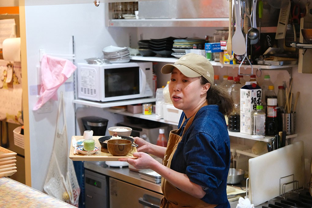 できた料理を客席に配膳する吉井さん