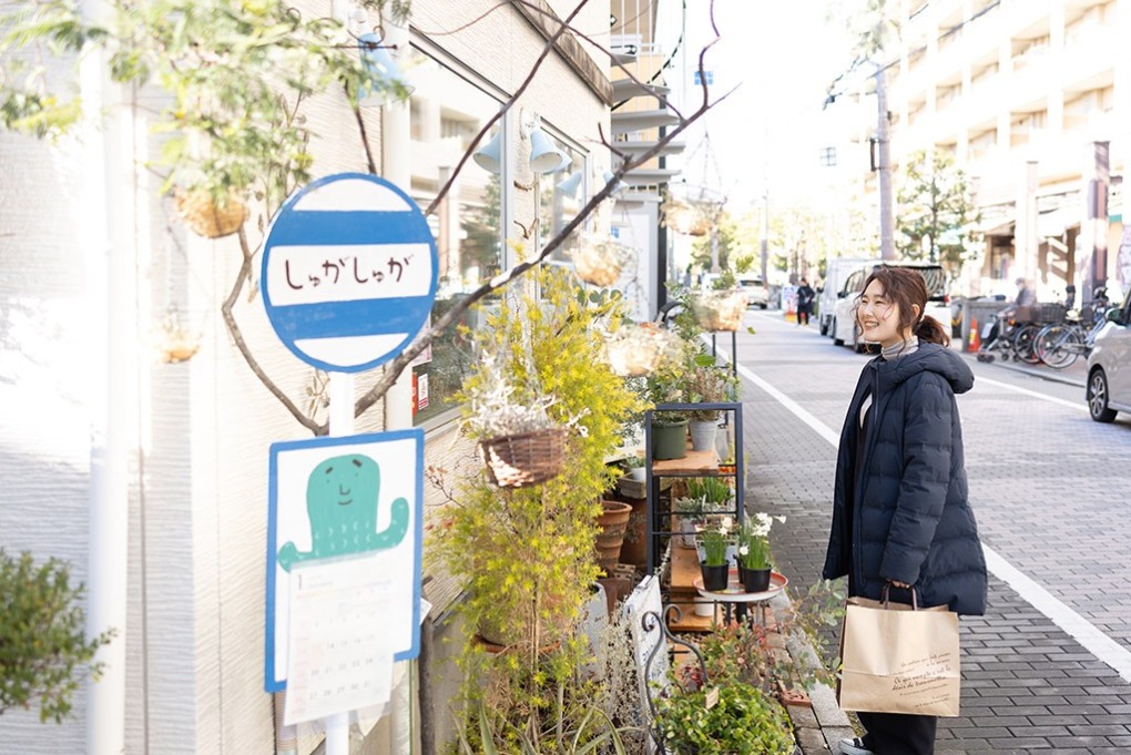 写真、花屋の前に立つ笑顔の高井さん