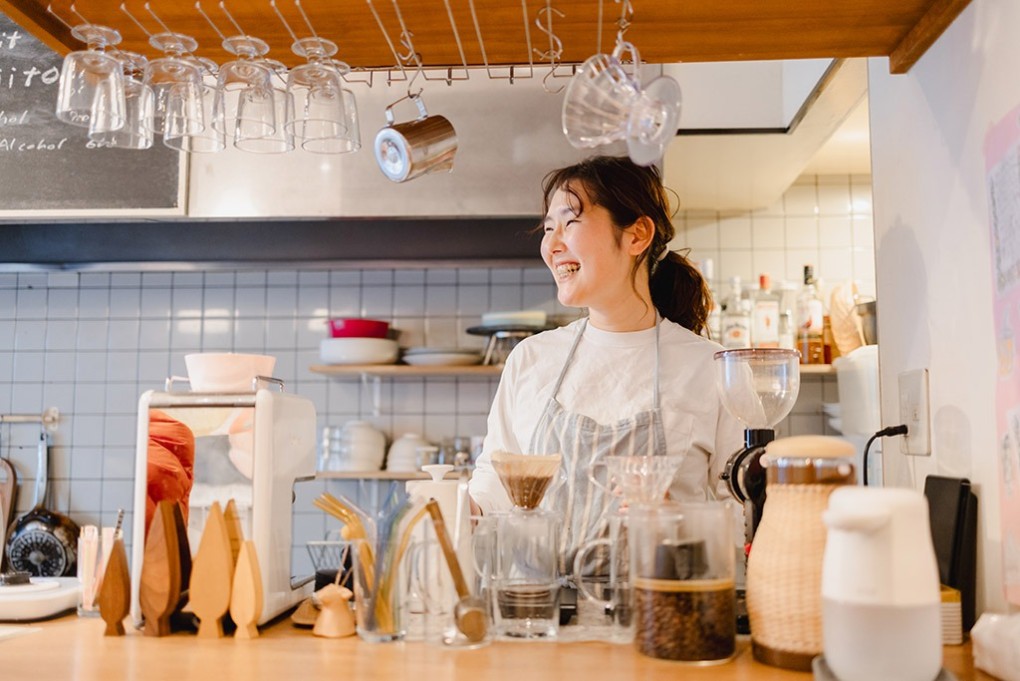 写真、カフェに立つ高井さん