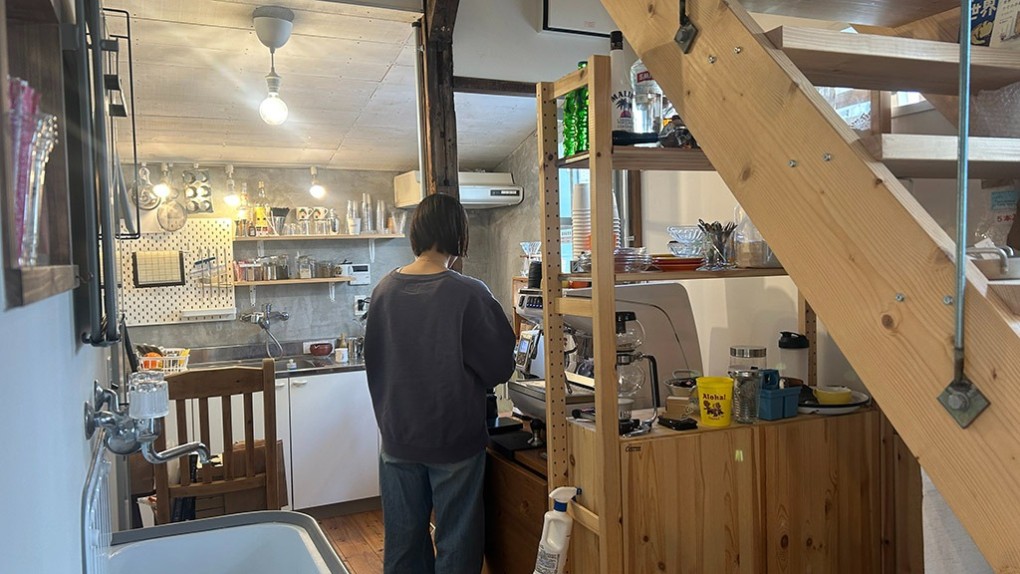 写真、カフェのキッチンに立つ吉川さん