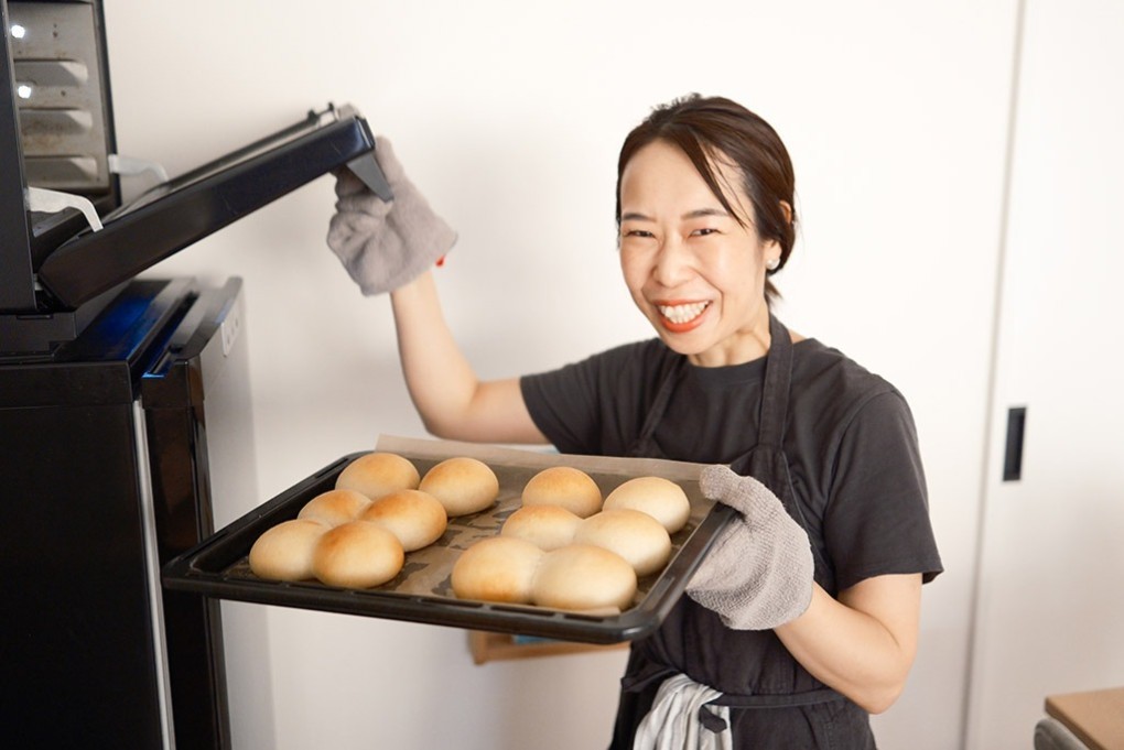 写真、オーブンから焼き上がったパンを手にする喜多村さん