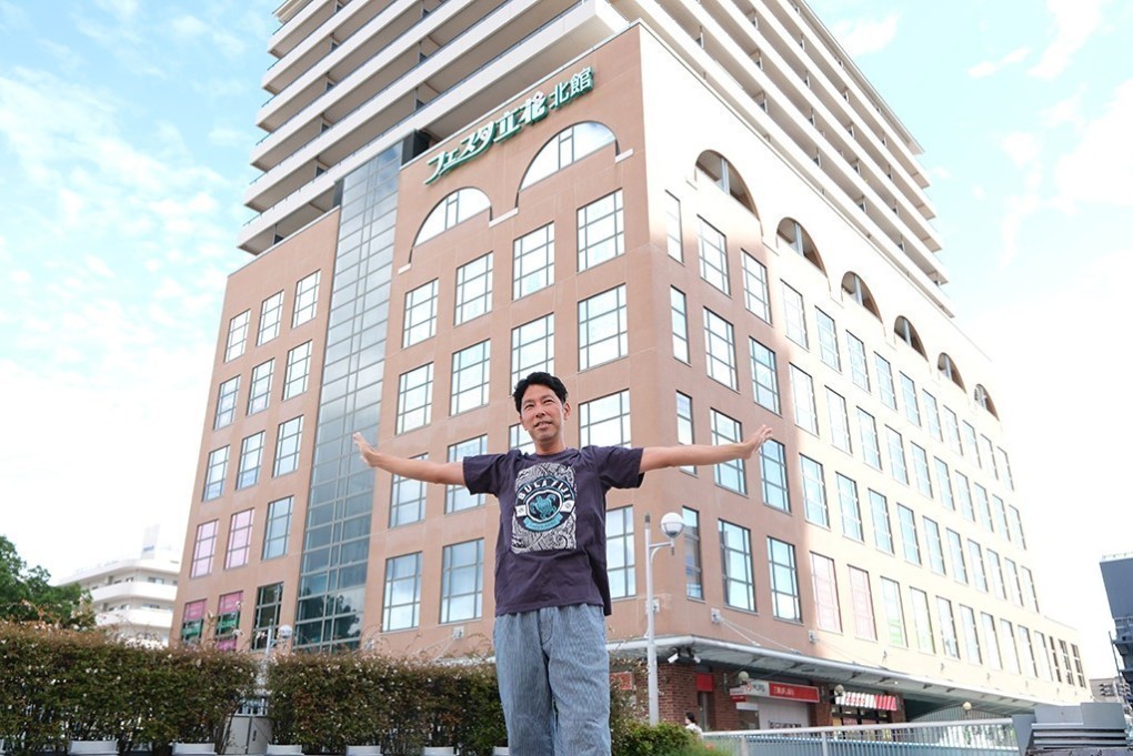 写真、建物の前に立つ永崎さん