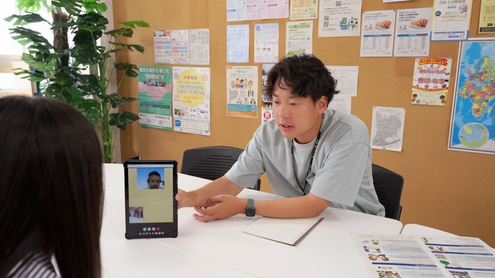 写真、通訳タブレットを利用しながら、相談者に対応する様子
