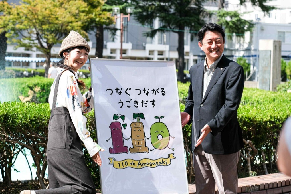 ロゴマークを前に松本市長とデザインしたホッシーナッキーさん（左）