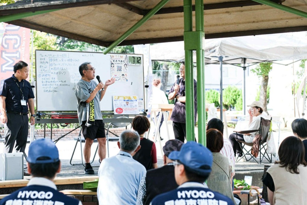 ランチミーティングで発表する男性（中央））