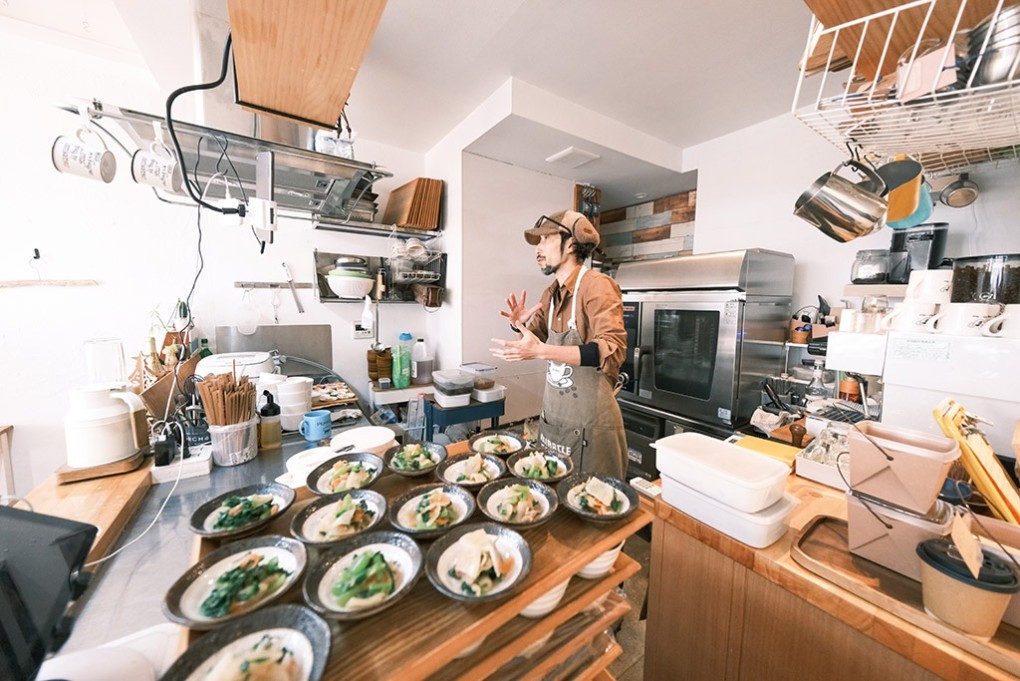 写真、キッチンでインタビューに答える長尾さん