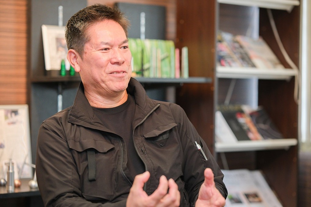 写真、デライトラボの事務所内で取材を受ける、金指博文さん