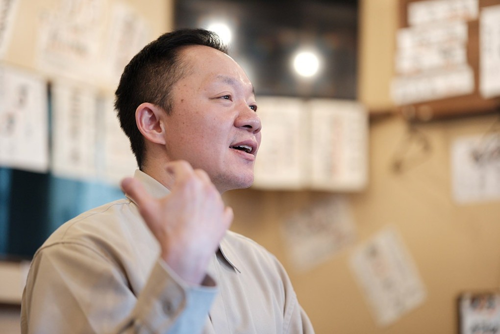 写真、インタビューに答える辻さん