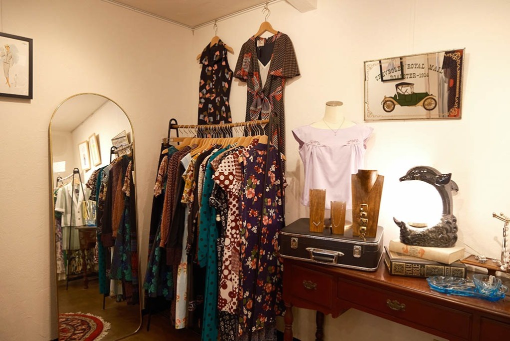 写真、あざらし洋品店の店内。アンティーク雑貨と服が並ぶ